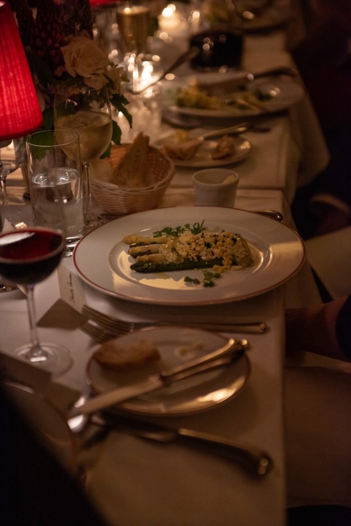 Candlelit dinner table with a plated course, seen close