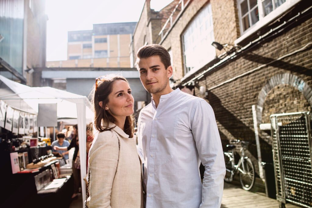Couple standing together at a street market stall in the late afternoon sun