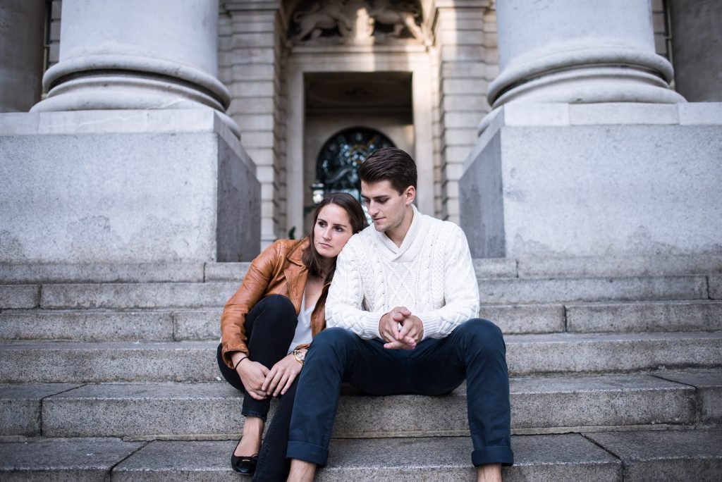 Couple sitting together on stone steps between two columns