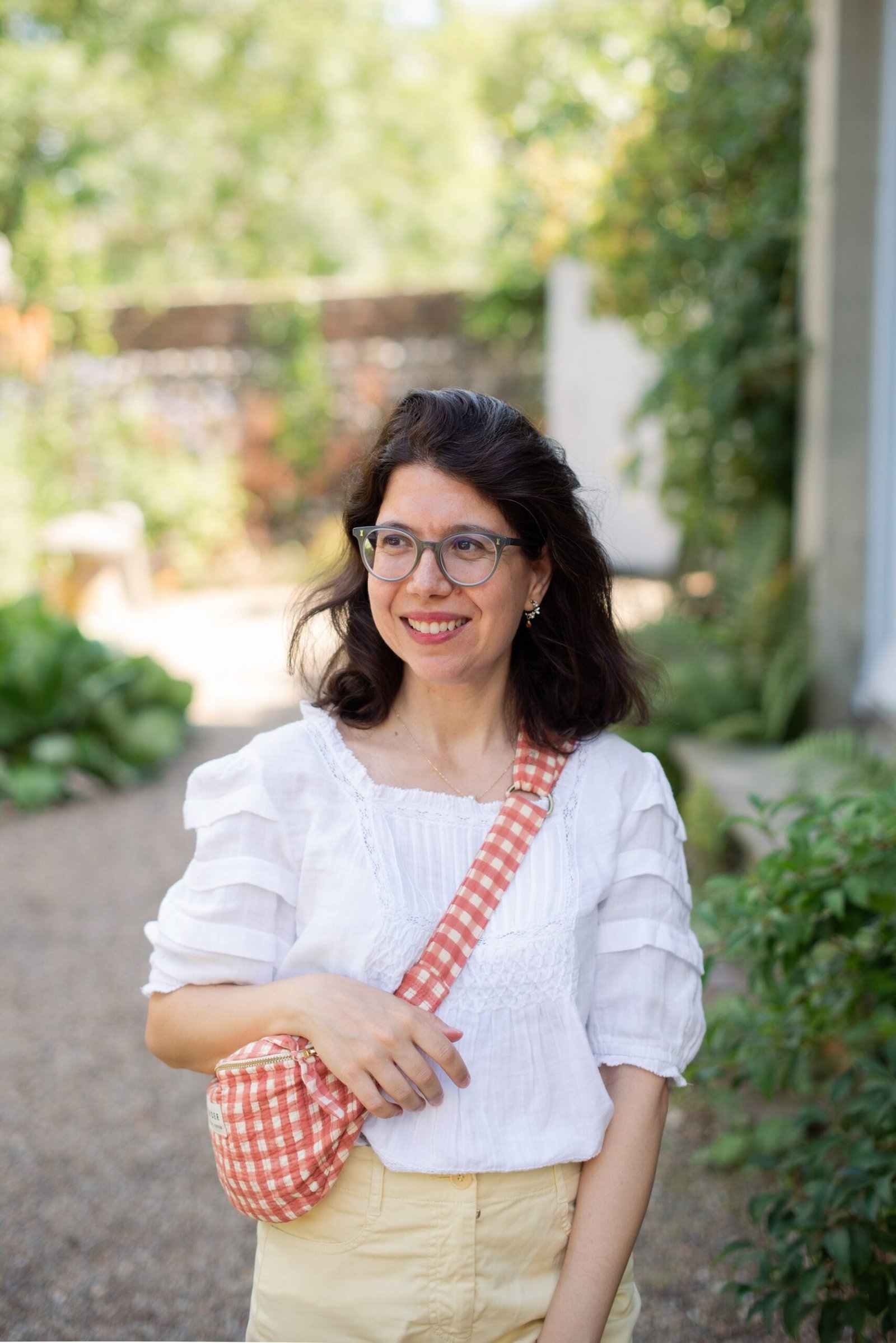 Flavia Catena, photographer, standing in a sunlit garden