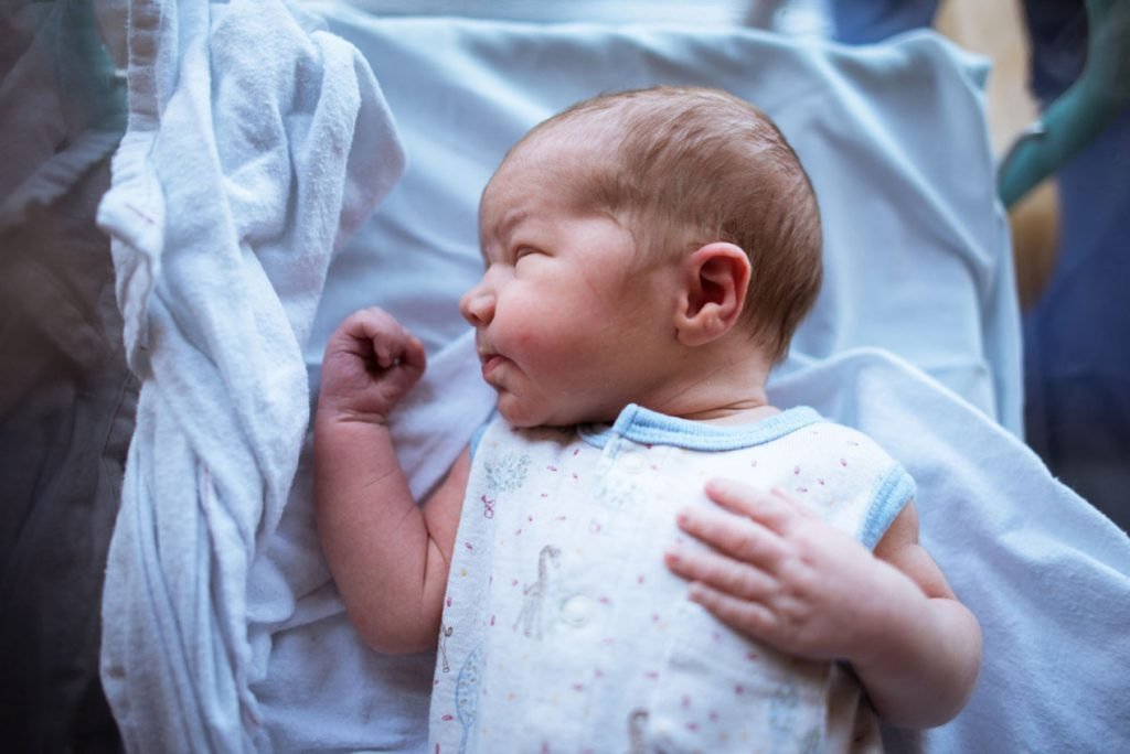 Newborn baby asleep in a white blanket
