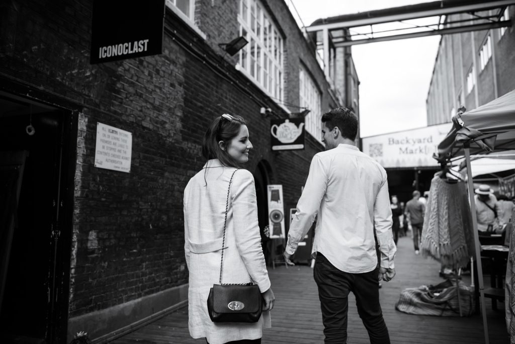 Couple walking through a covered street market, black and white photograph