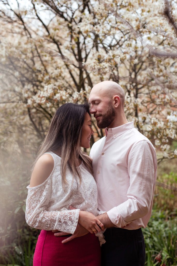 Couple holding hands under a magnolia tree in full blossom