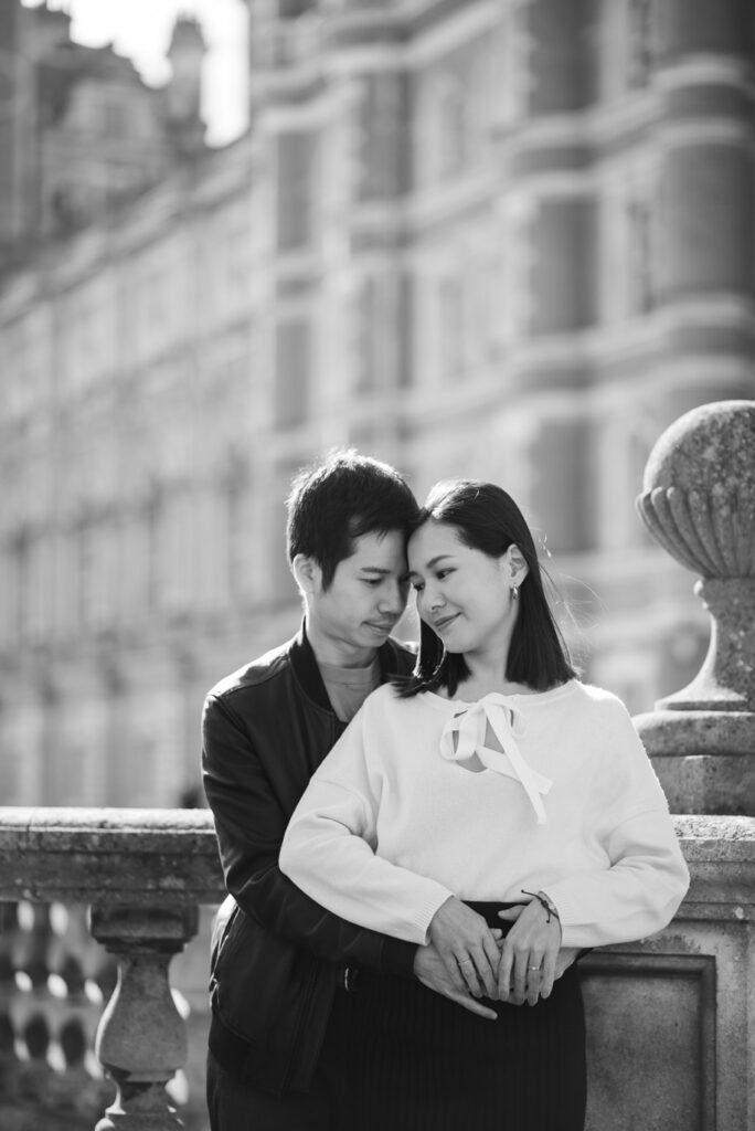 Couple standing close beside a stone balustrade, black and white photograph