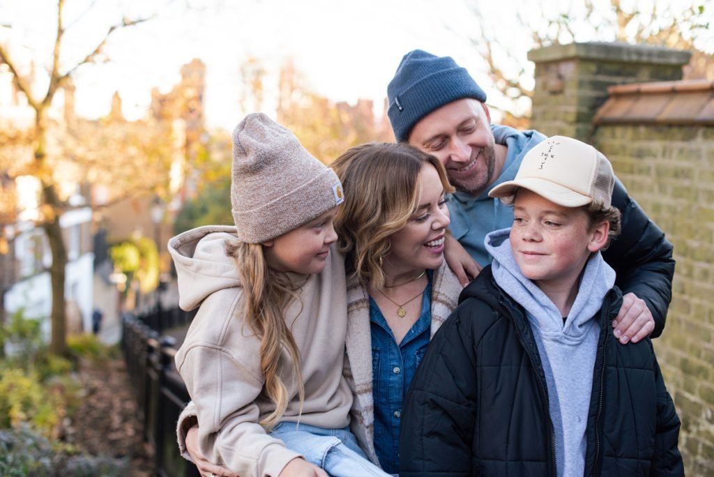 Family of four laughing together on an autumn walk