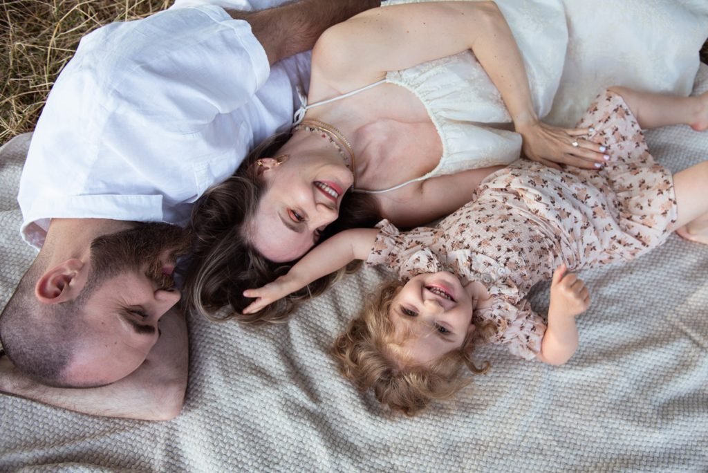 Family lying together on a blanket, seen from above