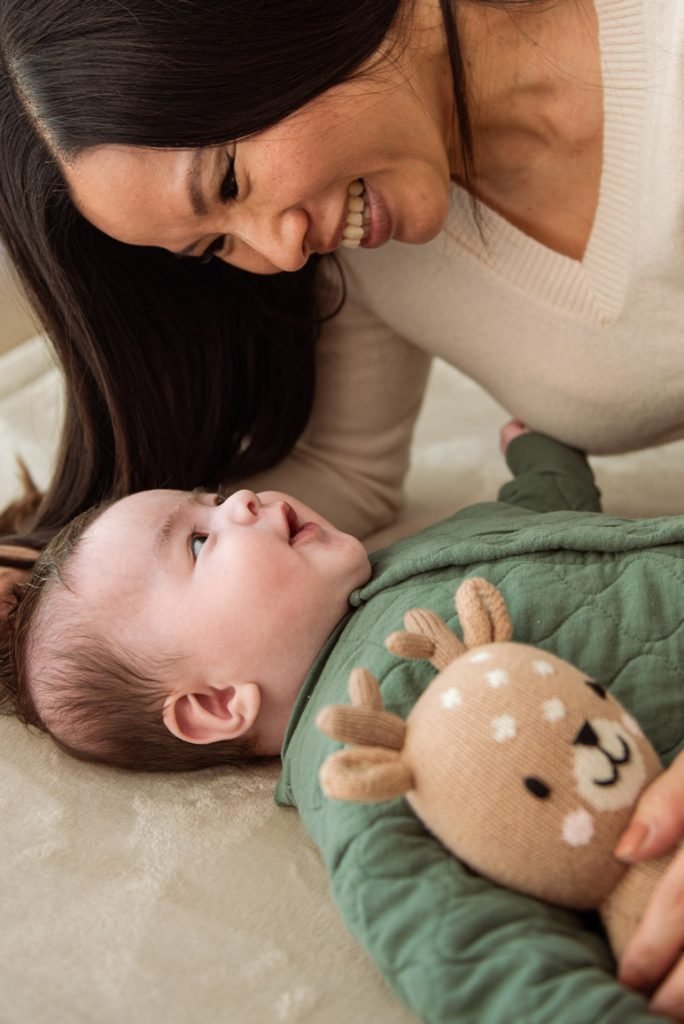Mother leaning over her baby, both laughing
