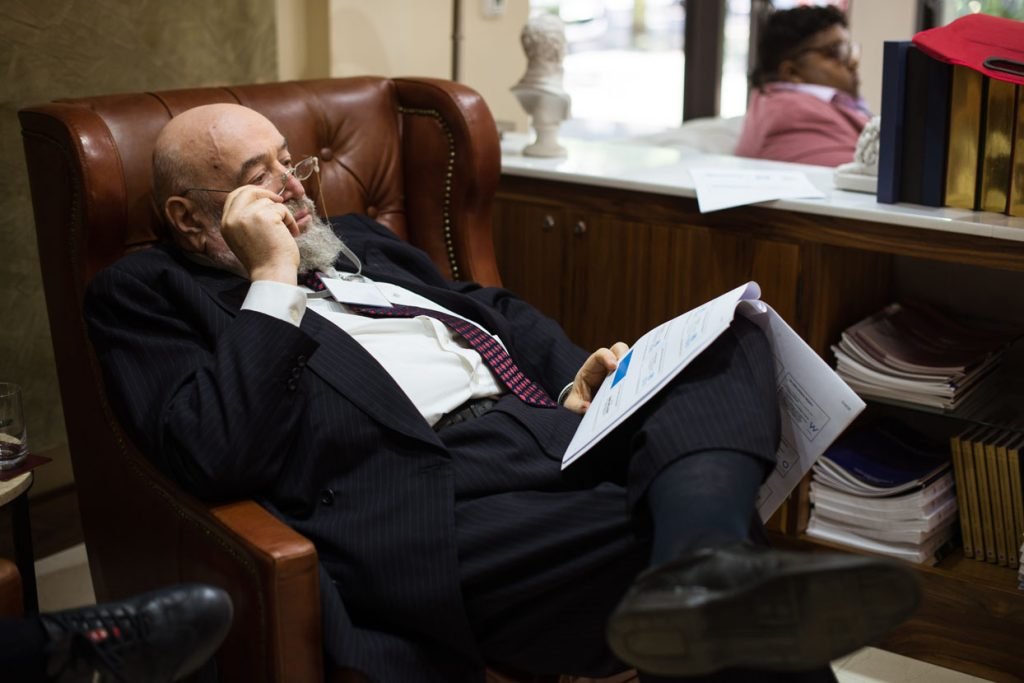 Delegate reading through papers in a leather armchair