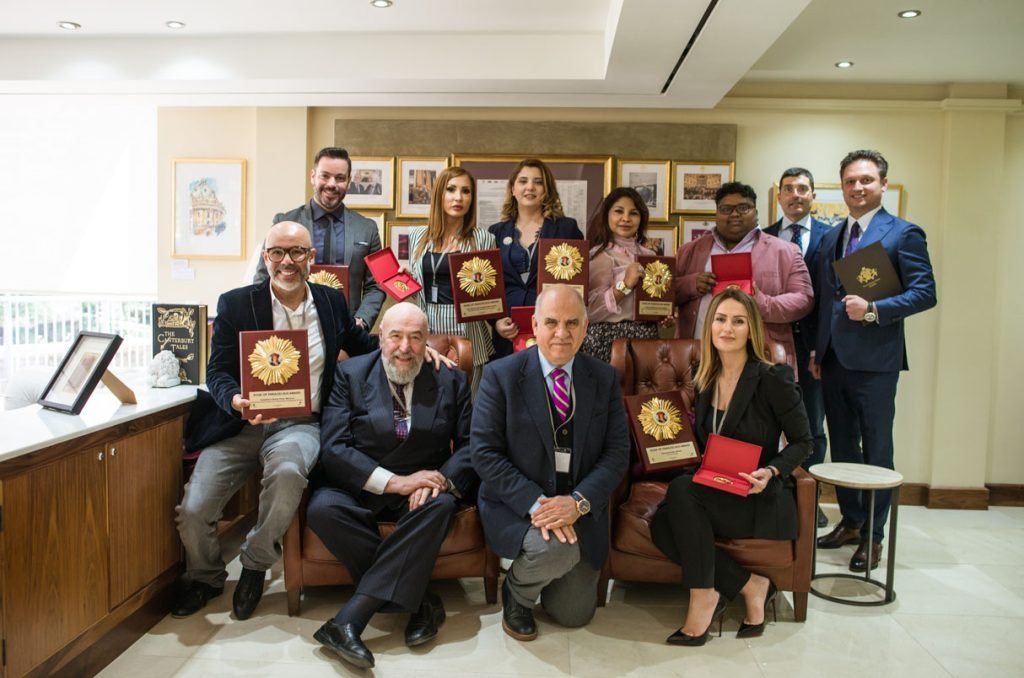 Group of award winners with their plaques, seated for a photograph