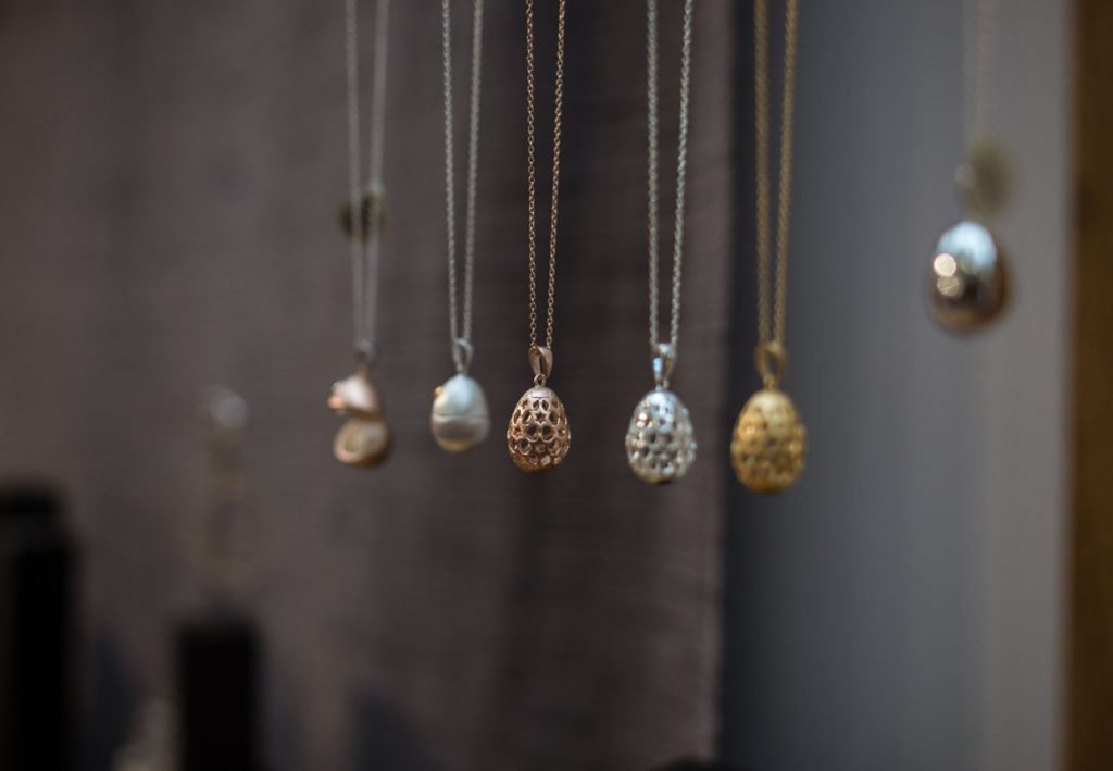 Row of pendant necklaces hanging on display