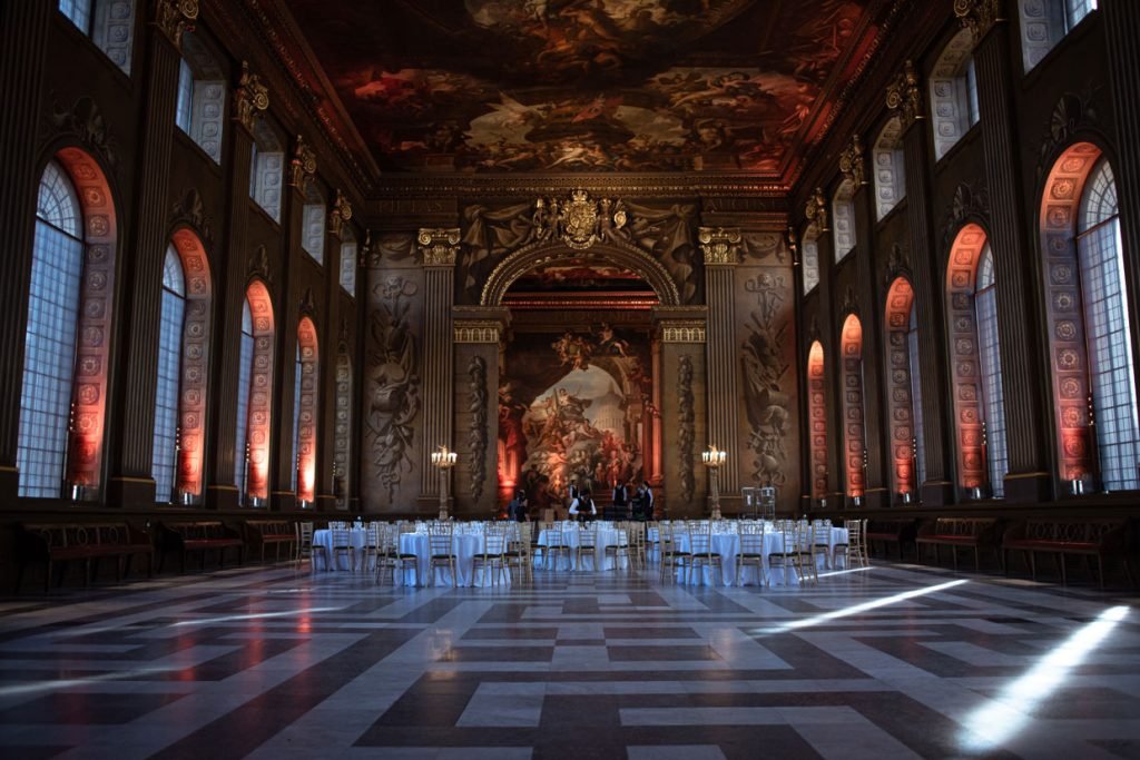 Empty painted hall laid out with round tables before a dinner