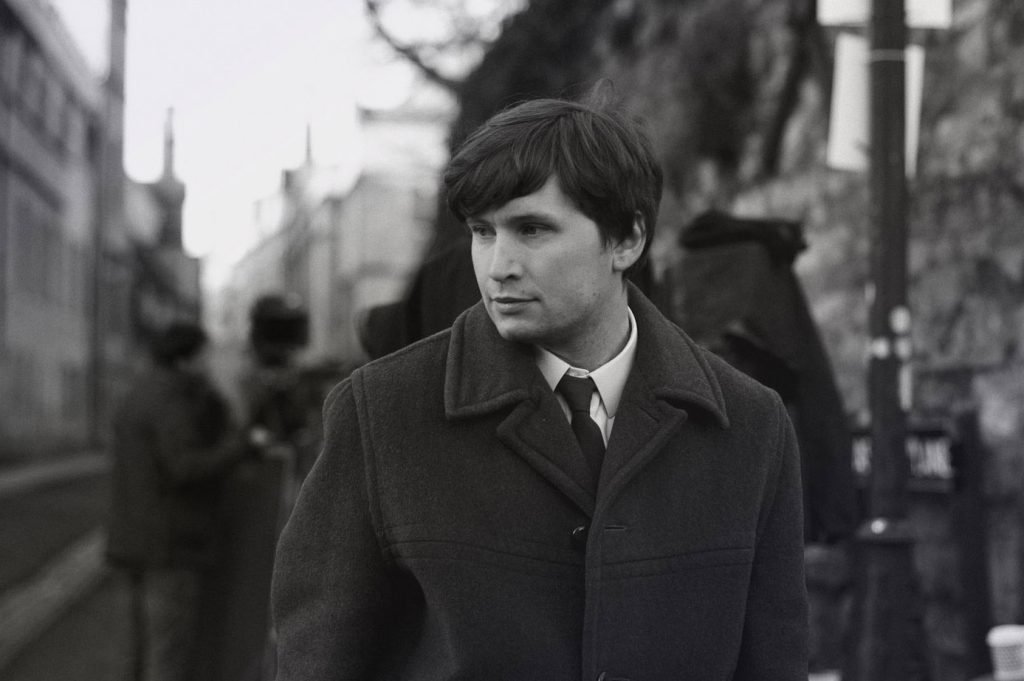 Man in a wool coat on a city street, black and white photograph
