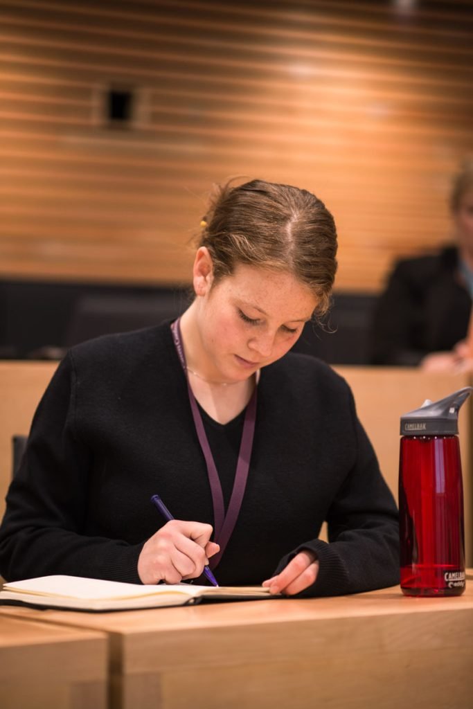 Delegate taking notes in a lecture theatre