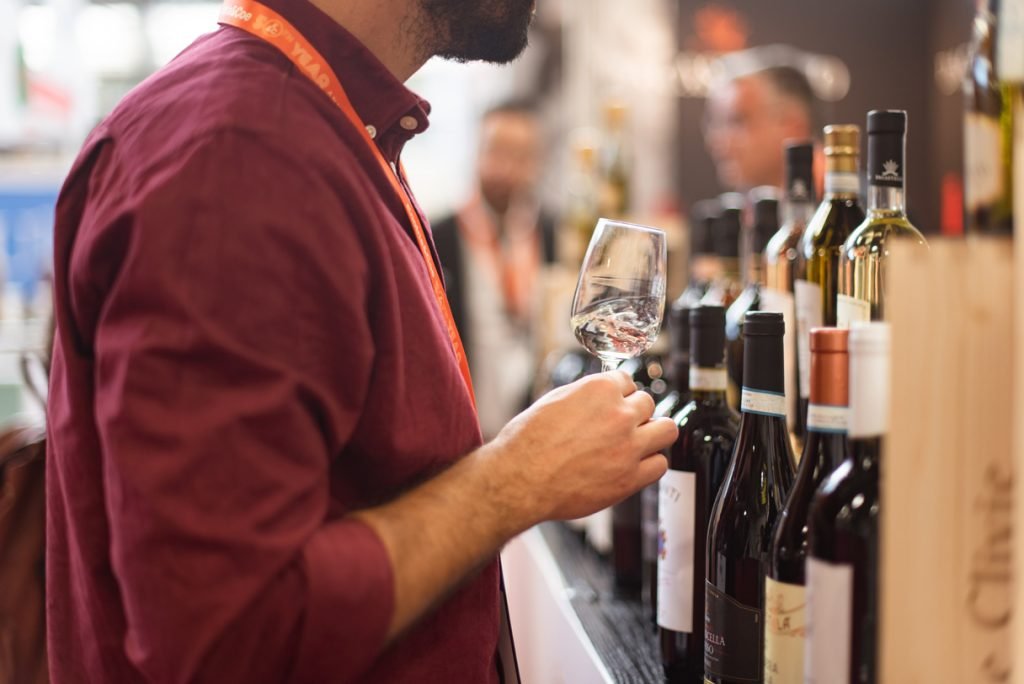 Exhibitor pouring a taste at a wine fair stand