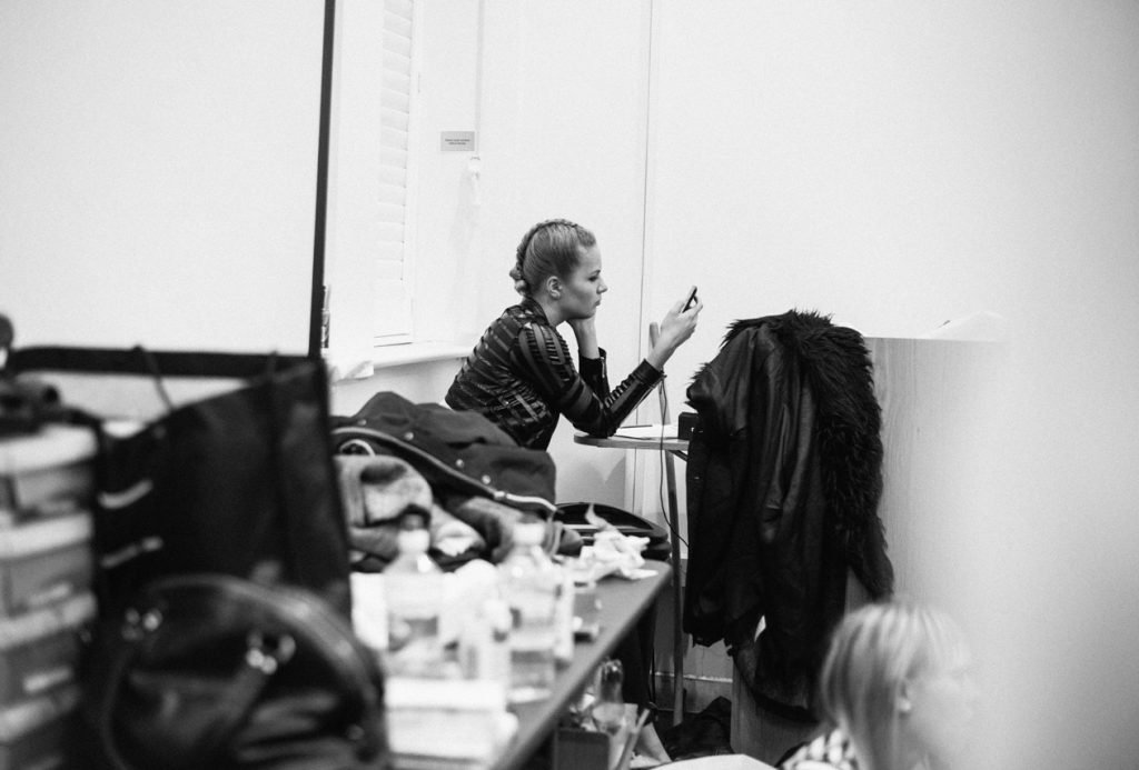 Performer getting ready at a cluttered dressing table, black and white photograph