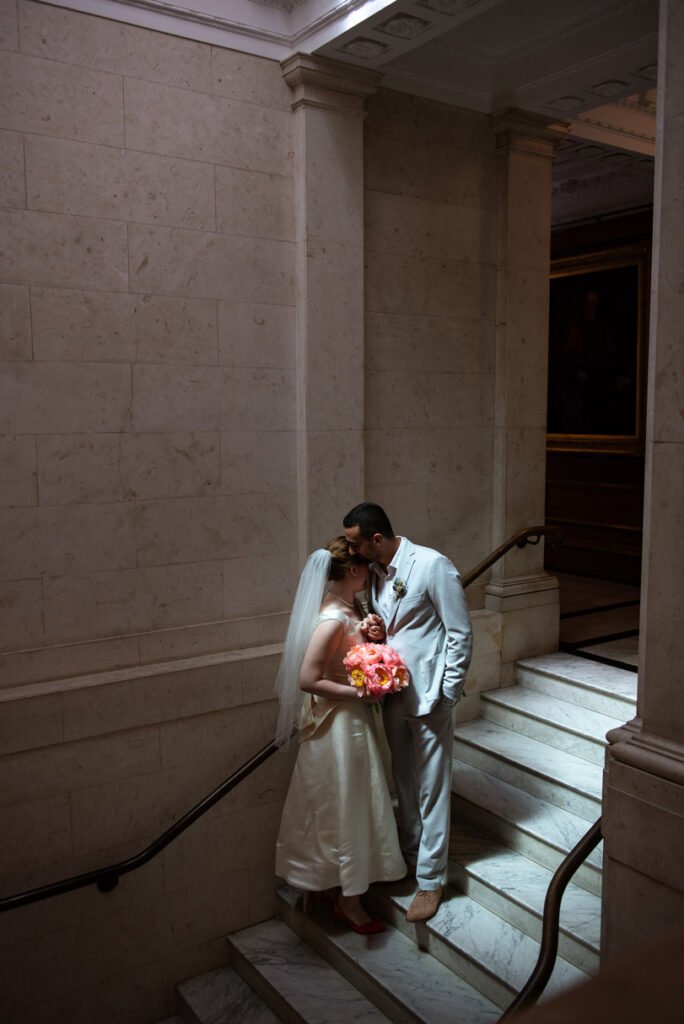 Bride and groom embracing on a stone staircase, seen from above