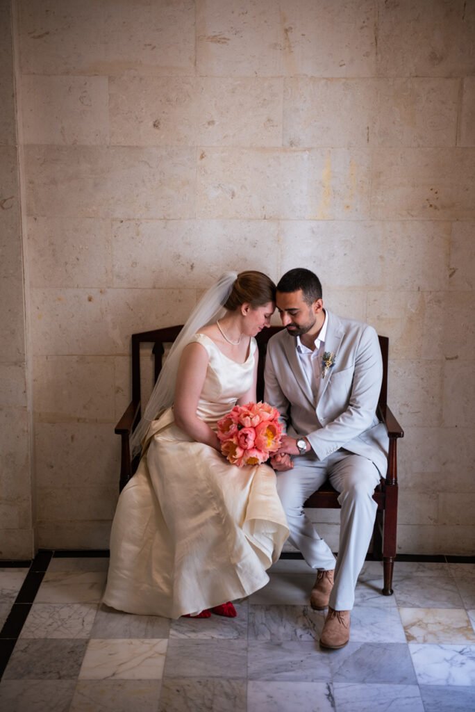 Bride and groom resting their foreheads together on a bench at the register office