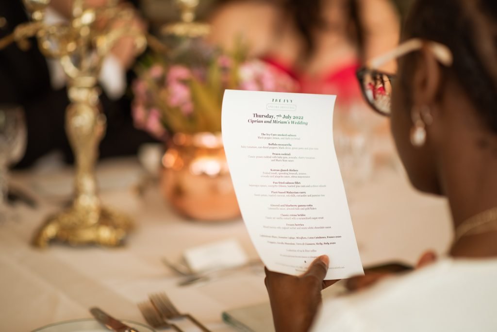 Guest reading the wedding menu card at a candlelit table