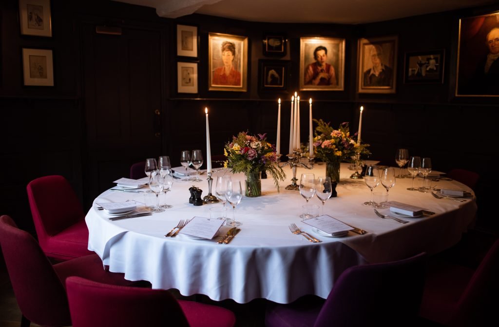 Round dining table laid with candles and flowers before the guests arrive