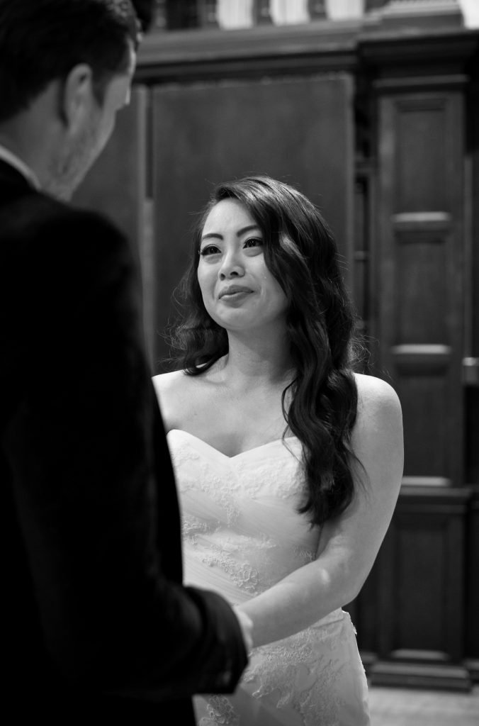 Bride facing her groom at the altar, black and white photograph
