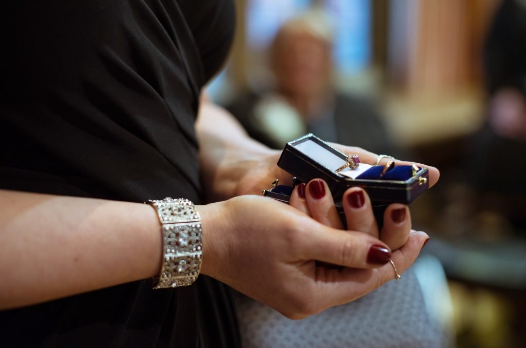 Guest holding an open pair of ring boxes