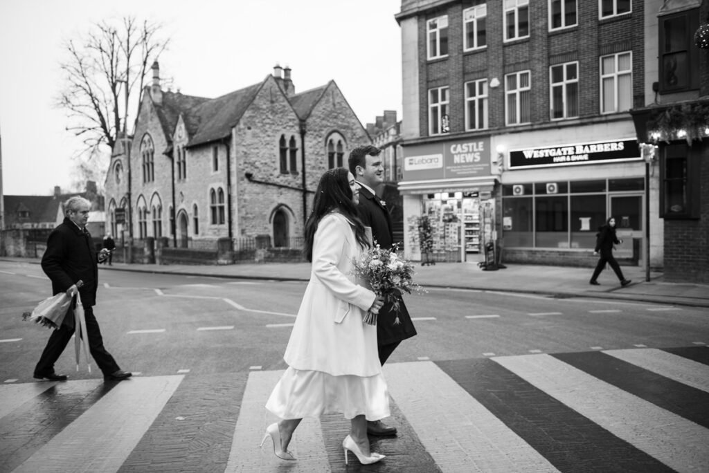 Bride crossing a zebra crossing in an Oxford street, black and white photograph
