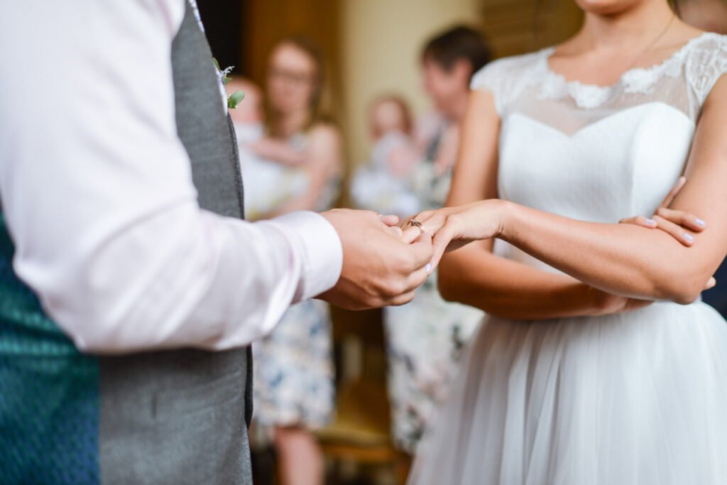 Groom sliding the ring onto the bride's finger during the ceremony