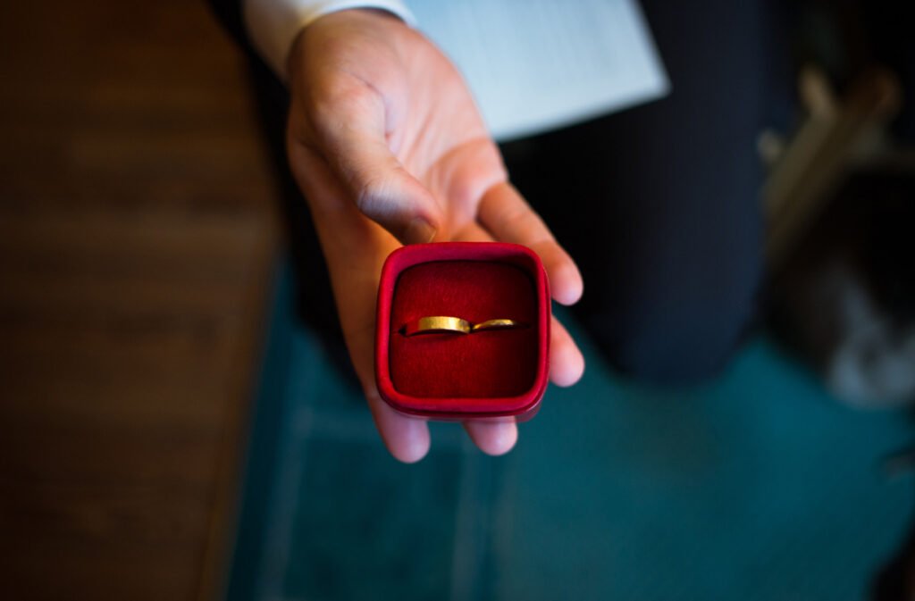 Hand holding open a red ring box