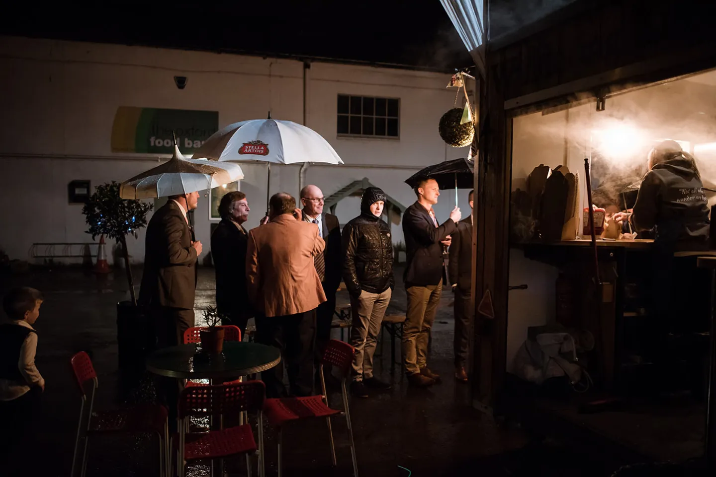 Guests waiting for their food during an evening reception outside.