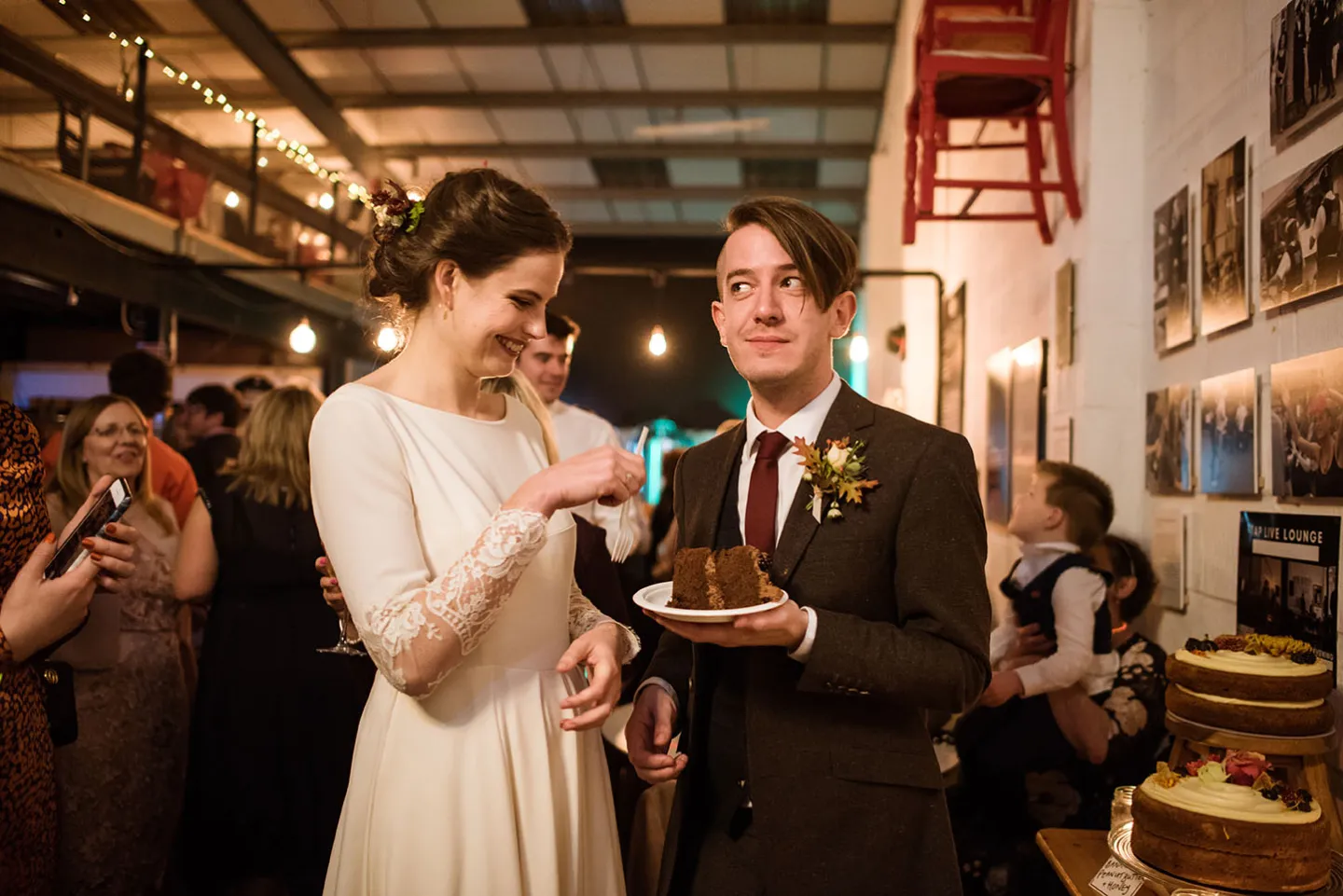 Bride and groom are eating their wedding cake.