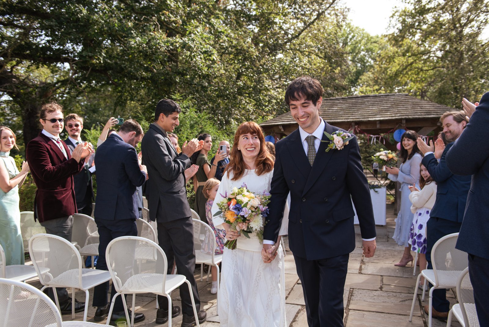 A couple walking at the end of their wedding ceremony at Pembroke Lodge, in Richmond, London.